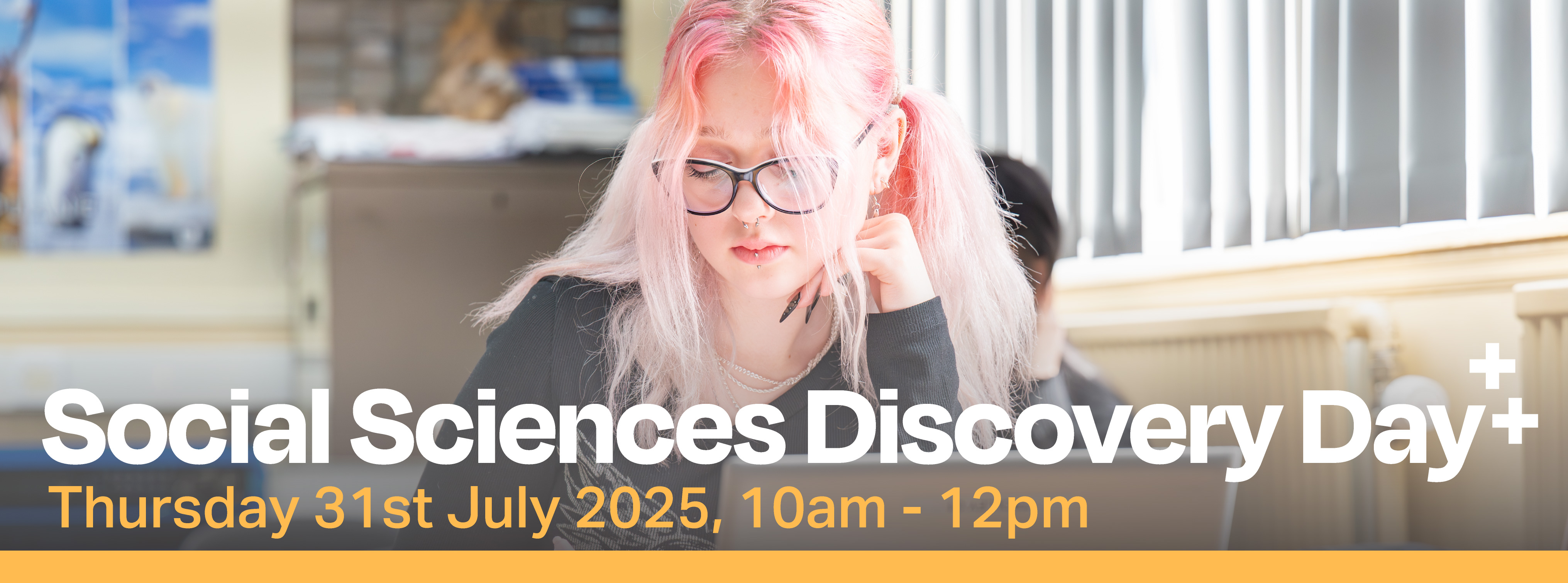 Photo of female student with pink hair working at in a classroom. On top is the words Social Sciences Discovery Day Thursday 31st July 2025, 10am - 12pm. A yellow strip runs long the bottom of the image