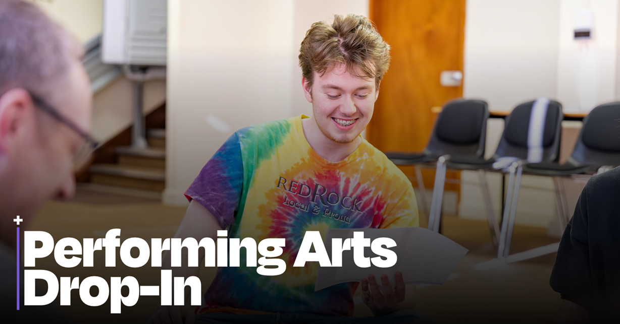 Photo of male acting student in a bright tie dye t-shirt reading a script. One top is the words Performing Arts Drop In