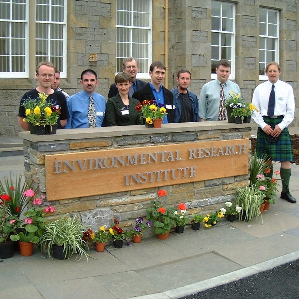 Group of people standing in front of the Environmental Research Institute sign