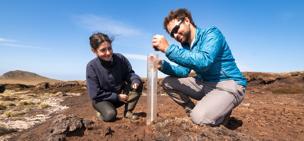 Two people measuring peat soil water content
