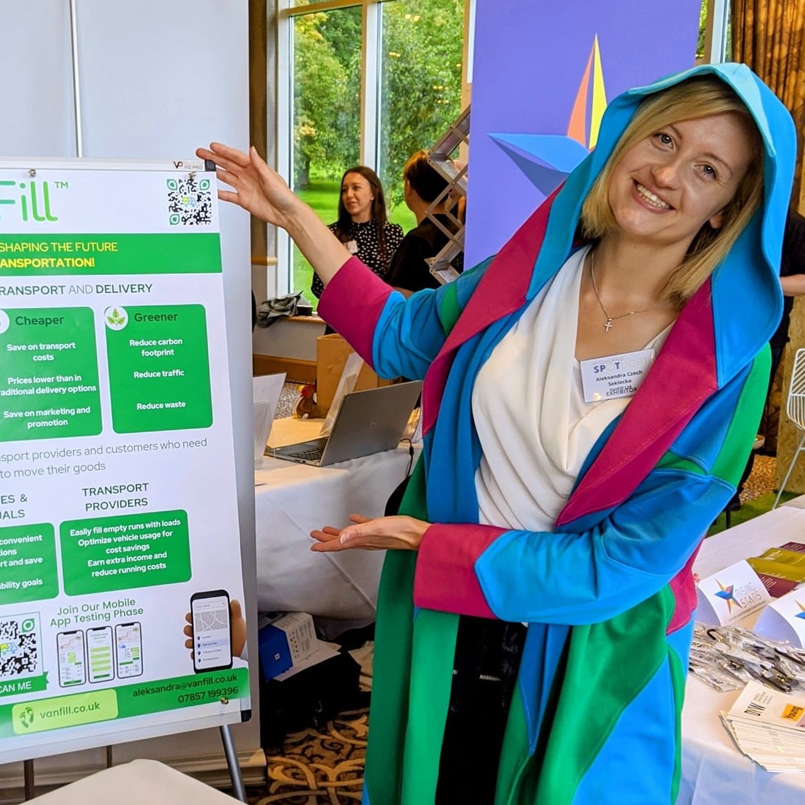 Aleksandra Czech-Seklecka in a colourful gown, standing in front of a sign for Van Fill