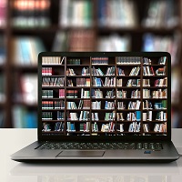 A laptop on a desk showing an image of bookshelves on its screen