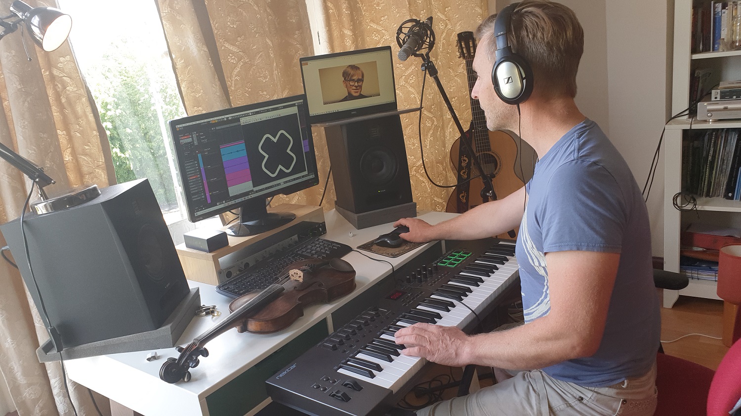 person with headphones using keyboards, computer screens