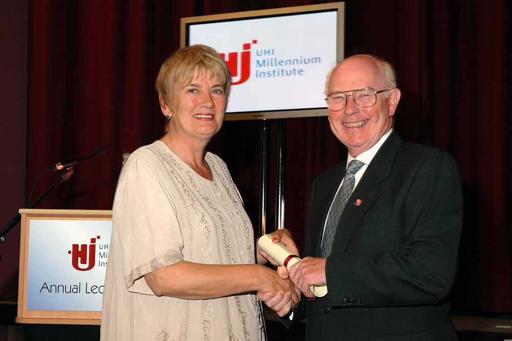 Dr Val MacIver OBE being presented with her Honorary Fellowship by Colin Mackay CBE FRCS former Chair of the Board for UHI Millenium Institute Board of Governors at the 2004 Annual Lecture held at UHI Orkney Kirkwall campus