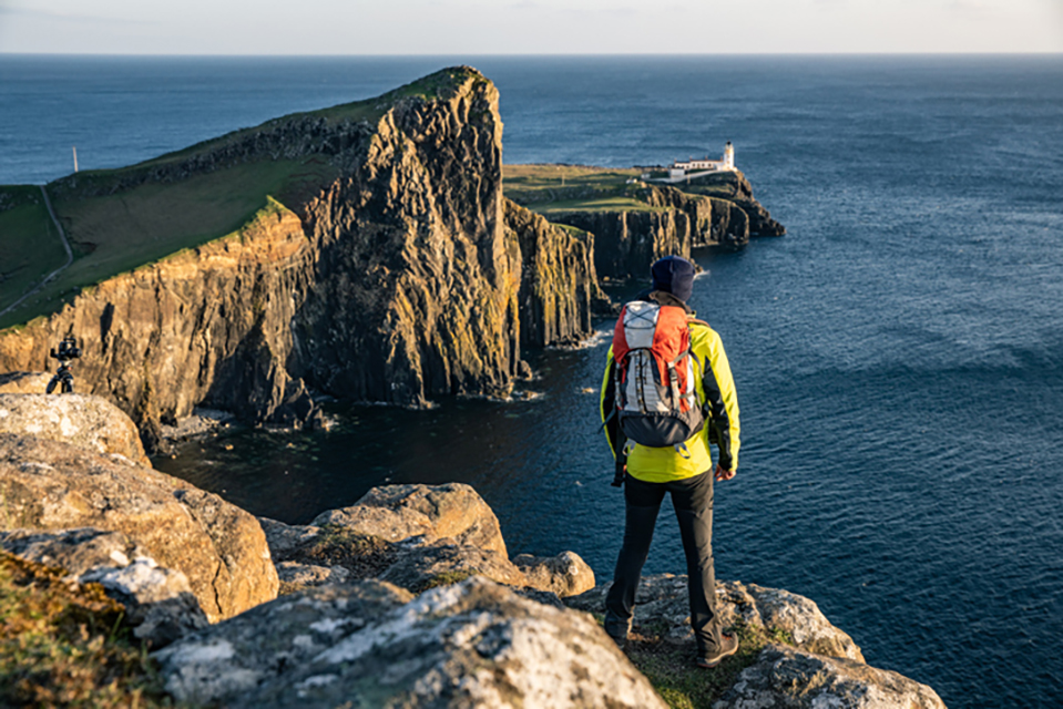 A person standing on the edge of a cliff overlooking Neist Point