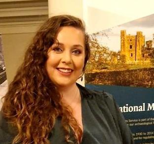 Woman smiling at a camera with a pop-up banner showing a ruined castle behind her. 