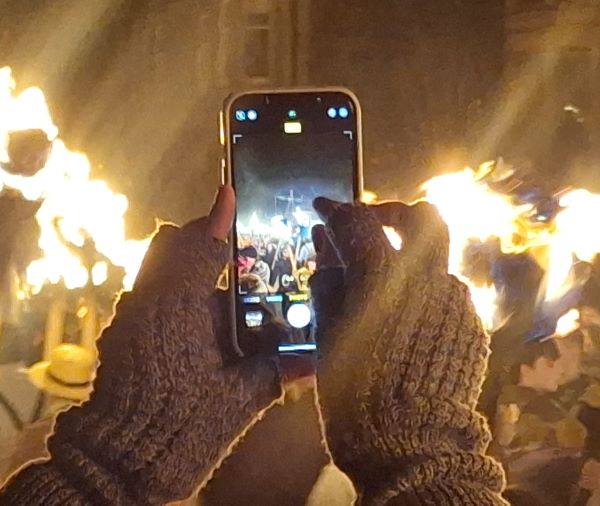 Someone taking a photograph of a bonfire at Up Helly Aa in Shetland