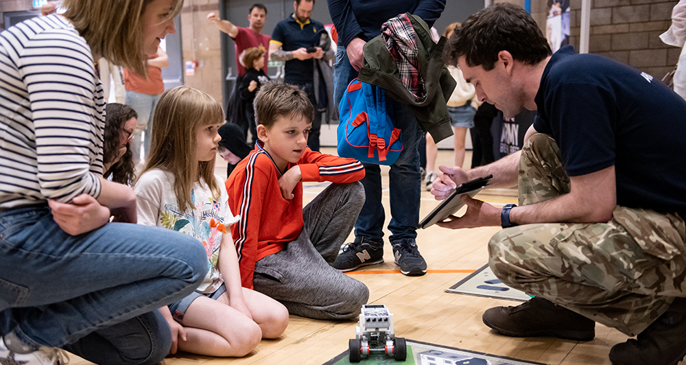 An adult explaining something on an Ipad to a child