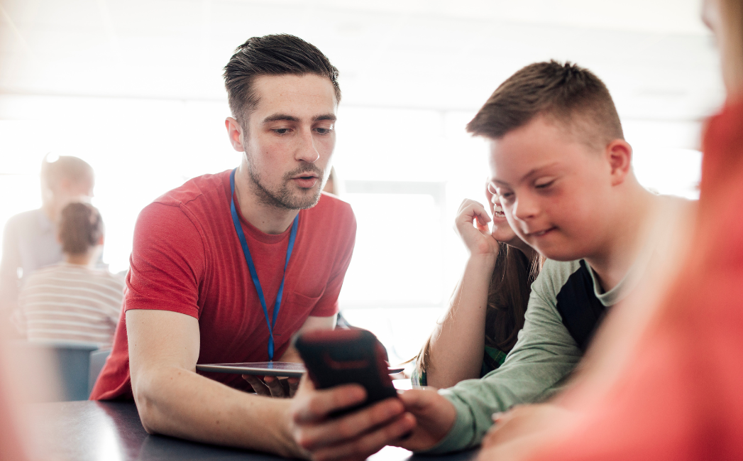 Teacher helping a student with a phone